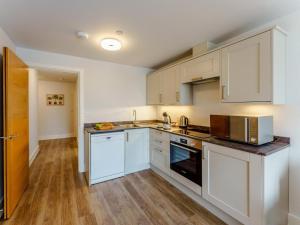 a kitchen with white cabinets and stainless steel appliances at 2 Bed in Brockenhurst oc-78729 in Brockenhurst +3 photos