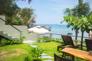 a patio with a table and chairs and the ocean at Chill Beach House in Phú Quốc