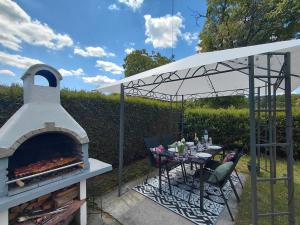 a outdoor pizza oven with a table and a table at Vacation house Terra in Petrovina