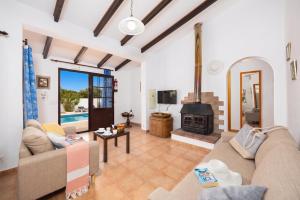 a living room with a couch and a fireplace at Villa Ca Nostra in Cala en Porter
