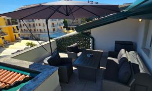 a balcony with a table and chairs and an umbrella at Residenza Tulipano in Eraclea Mare