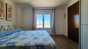 a bedroom with a bed and a large window at Residenza Tulipano in Eraclea Mare