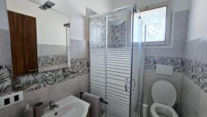 a bathroom with a toilet and a sink and a shower at Residenza Tulipano in Eraclea Mare +2 photos