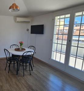 a dining room with a table and chairs and a tv at Residenza Tulipano in Eraclea Mare