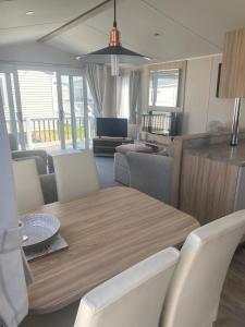 a dining room and living room with a table and chairs at Aqua bay whistable in Swalecliffe