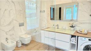 a white bathroom with a sink and a toilet at Istrian Lux Residence by Istrian apartments Koper in Koper