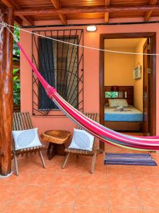 a hammock in a room with a bedroom at Tico Adventure Lodge in Sámara