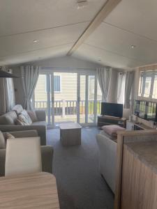 a living room with a couch and a table at Aqua bay whistable in Swalecliffe