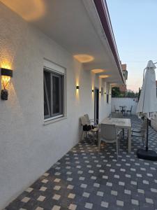 a patio with a table and chairs and an umbrella at Casa Del Sol Pogradec in Pogradec