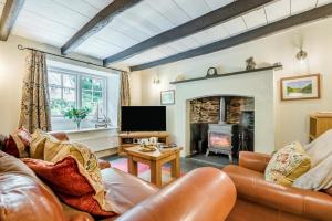 a living room with a couch and a fireplace at 2 Bed in Looe oc-l30015 in Lansallos
