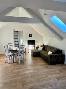 a living room with a couch and a table and chairs at Halleluja mit Burgblick in Hellenthal +30 photos