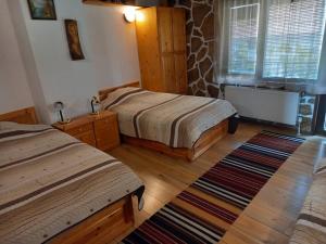 a bedroom with two beds and a rug at Deny Holiday home in Dobrinishte +21 photos