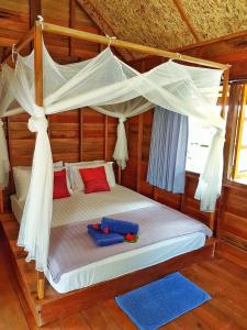 a bedroom with a canopy bed with blue towels on it at Lipe Beach Resort in Ko Lipe