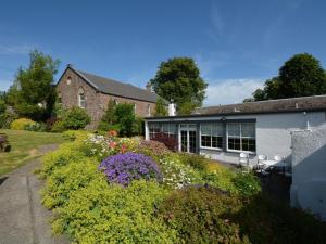 a house with a garden with flowers in front of it at 1 Bed in Kelso oc-52538 in Morebattle