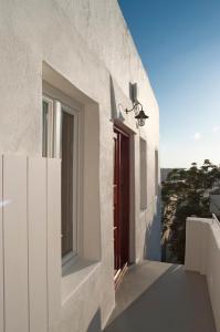a white house with a red door and a window at Casal Paleologos Villa in Mikonos
