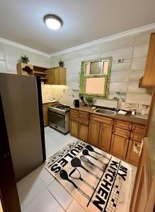 a kitchen with a sink and a counter with a sign on the floor at Modern Flat at Shiekh Zayed in Sheikh Zayed