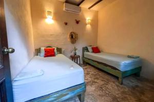 a room with two beds in a room at Hostal Mulut Tulum in Tulum