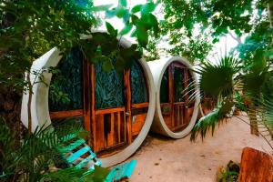 a circular wooden fence in a yard with trees at Hostal Mulut Tulum in Tulum