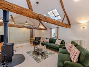 a living room with a fireplace and green furniture at 2 Bed in Settle oc-g0051 in Settle
