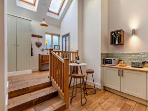 a kitchen with a staircase and a table with stools at 2 Bed in Settle oc-g0051 in Settle