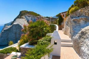 a walkway on a cliff next to the ocean at Maridea - Il Paradiso sulla Baia in Ponza