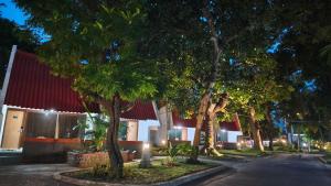 a row of trees in front of a building at night at Votel Manyar Resort Banyuwangi in Ketapang