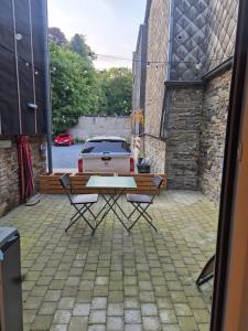 a patio with a table and a car in a parking lot at Chambres d'hotes in Bertrix