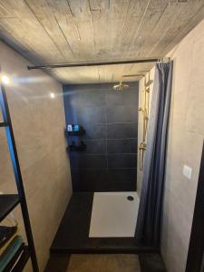 a bathroom with a shower with a shower curtain at Chambres d'hotes in Bertrix