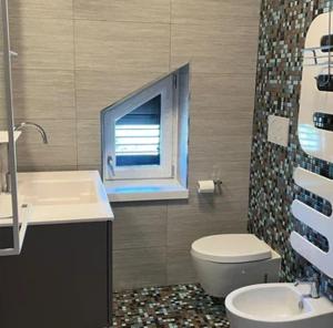 a bathroom with a sink and a toilet and a window at Suite del Colonnello B&b in Rionero in Vulture