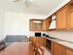 a kitchen with wooden cabinets and a wooden table at SE238 - Marotta, quadrilocale con corte privata in Marotta