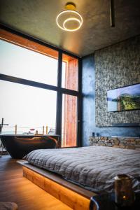 a bedroom with a bed and a large window at Ascent Lodge -Jacuzzi si Panoramic View in Petreasa +15 photos