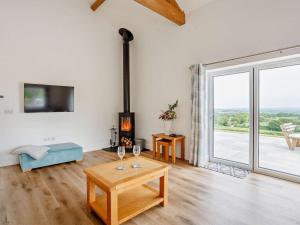 a living room with a fireplace and a table with wine glasses at 4 Bed in Chard oc-83501 in Combe Saint Nicholas