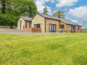 a brick house with a grassy field in front of it at 4 Bed in Chard oc-83501 in Combe Saint Nicholas