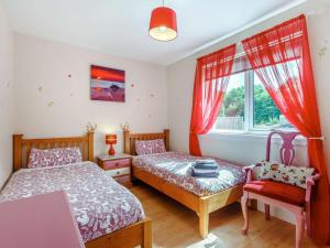 a bedroom with two beds and a table and a window at 2 Bed in Inverness oc-44481 in Drumnadrochit