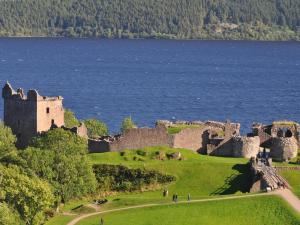 a castle on a hill next to a body of water at 2 Bed in Inverness oc-44481 in Drumnadrochit