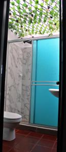 a bathroom with a glass shower door and a toilet at Hotel Rancho Olimpo in Sesquilé
