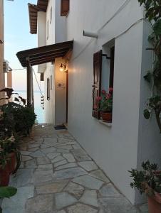 a hallway of a white building with flowers in a window at Irida mariaSmall studio in Agios Ioannis Pelio