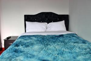 a bedroom with a blue blanket on a bed at Hotel Rancho Olimpo in Sesquilé +14 photos