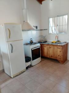 a kitchen with a white refrigerator and a stove at El Galpon Aparts in General Pacheco