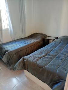 two beds sitting in a room with a window at El Galpon Aparts in General Pacheco