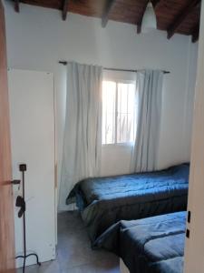 a bedroom with two beds and a window at El Galpon Aparts in General Pacheco