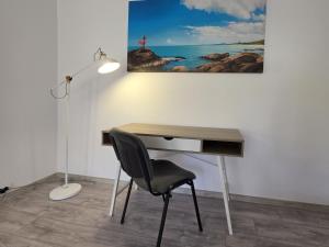 a desk with a chair and a desk with a picture on the wall at Konstanzer Podu Ros 11 - Spacious Apt - Palas Mall - AC in Iaşi +16 photos