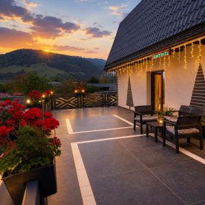 a patio with benches and red flowers and a building at Fram Apartments in Soci