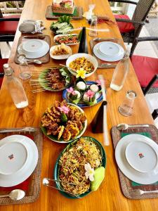 a wooden table with plates of food on it at Daphne Homestay & Cooking Class in Senggigi +192 photos