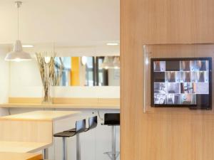 a kitchen with a counter with a tv on a wall at hotelF1 Cholet in Cholet