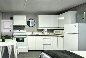 a white kitchen with white cabinets and appliances at Motel Express in Saint-Antonin