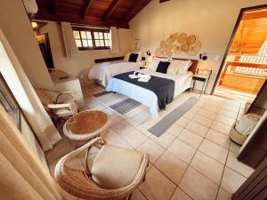 a bedroom with two beds and wicker chairs at Hotel Pousada da Lagoa - Casa Californiana in Garopaba +113 photos