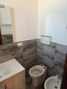 a bathroom with a toilet and a sink at Illumina House 3 in Giurdignano +9 photos