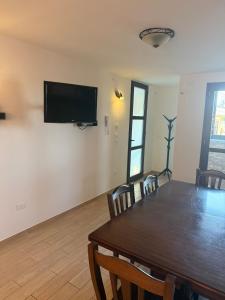 a dining room with a table and a television on a wall at Illumina House 3 in Giurdignano