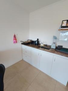a kitchen with white cabinets and a counter top at SAN jose in Federación